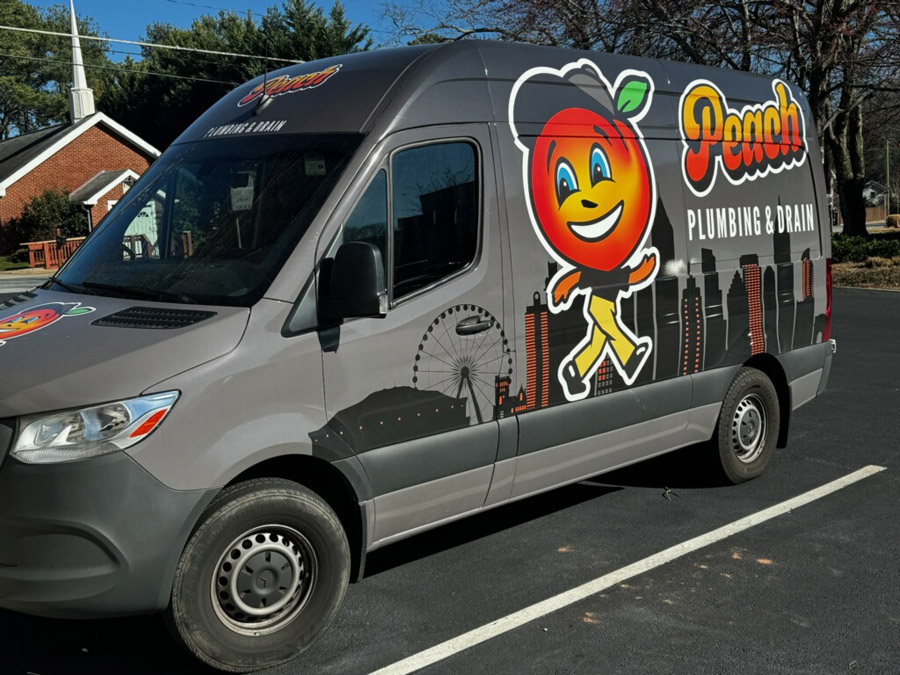 Peach Plumbing & Drain service van featuring the smiling peach mascot and Atlanta skyline graphic, representing trusted local plumbing services in Atlanta.